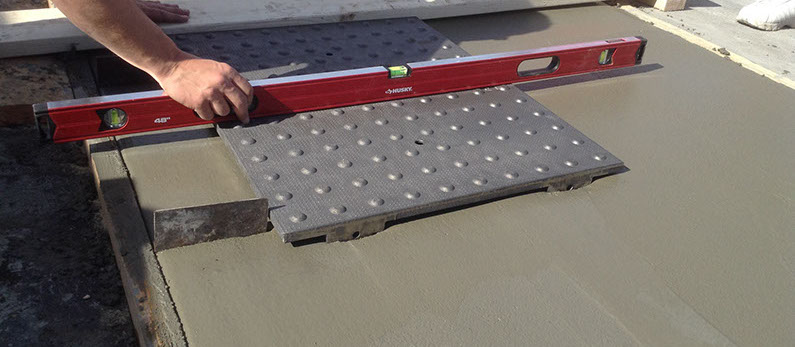 4. Tamp the tile in grid pattern across the top face, embedding the tile into the concrete using a rubber mallet or vibrate into place using a vibrating mechanism fixed with a soft base such as wood.